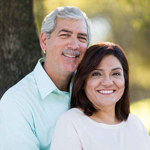 Older man and woman smiling after orthobiologic injection