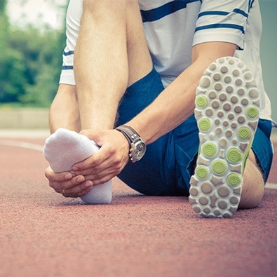 Person with plantar fasciitis holding foot