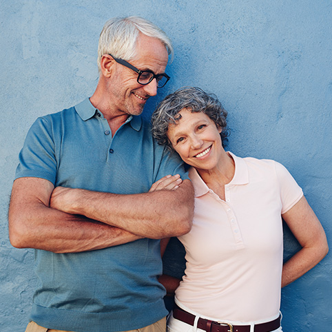 Older man and woman smiling after treatment for arthritis in the hands