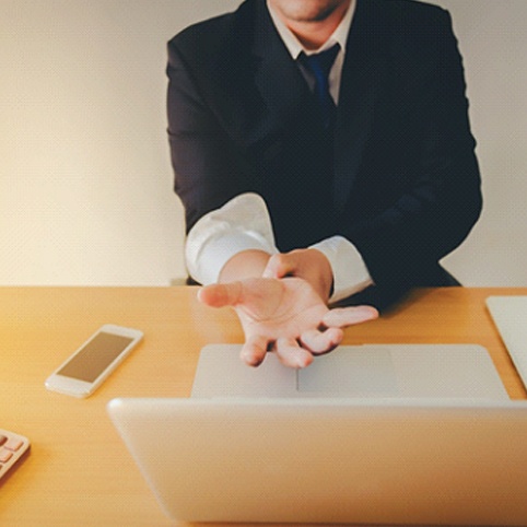 man holding wrist at desk due to carpal tunnel syndrome symptoms 