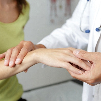 doctor holding woman’s wrist who may have carpal tunnel syndrome 