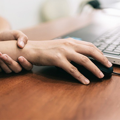 Person with carpal tunnel syndrome using computer mouse