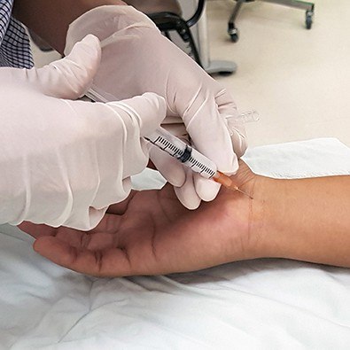 Doctor providing injection treatment for carpal tunnel syndrome