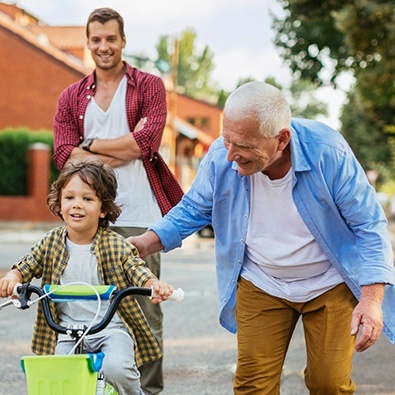 Grandfather teaching grandson how to ride a bike