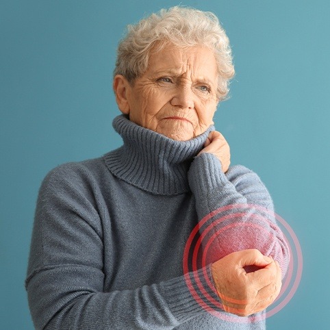 Older woman with elbow arthritis holding arm