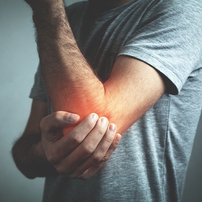 Man with elbow arthritis holding arm