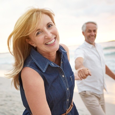 Man and woman smiling at beach after hand and wrist injury treatment