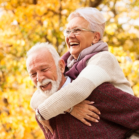 Older man and woman smiling together after treatment for join instability and impingement