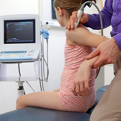 Doctor examining child for signs of little league elbow