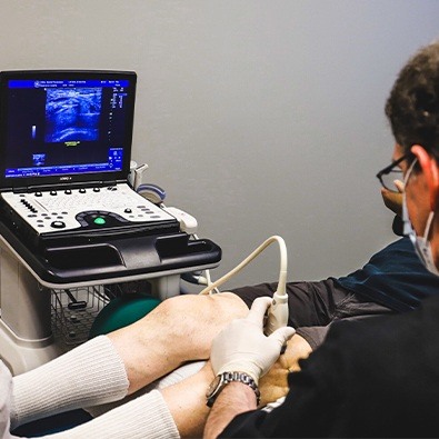 Doctor using ultrasound to diagnose meniscal tear