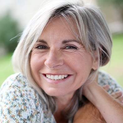 Woman smiling after treatment for neck pain