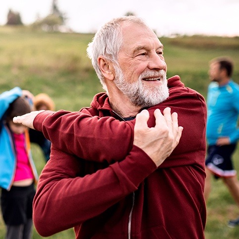 Older man stretching to relieve pitcher's elbow pain