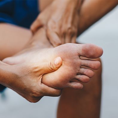 Man in pain from plantar fasciitis holding foot