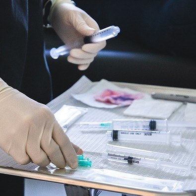 Doctor lining up needles for prolotherapy injections