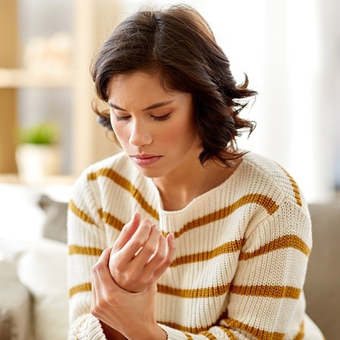 Woman in need of pronator syndrome holding arm