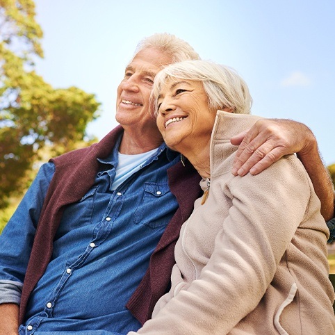 Older man giving woman a hug after radial tunnel syndrome treatment