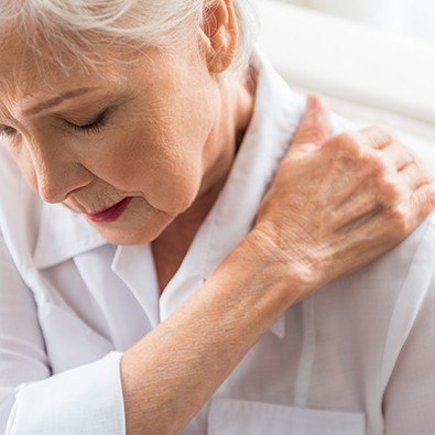 Older woman holding shoulder after rotator cuff injury