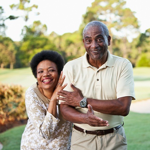 Older man and woman smiling together after shoulder arthritis treatment