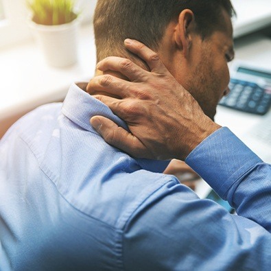 Man with osteoarthritis holding his neck