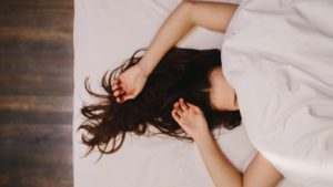 woman sleeping with hands above head  