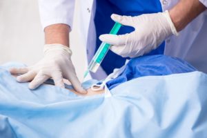 doctor injecting a patient’s back 