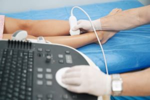 Medical team member using ultrasound on patient’s leg