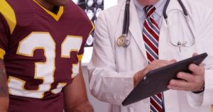 Doctor consulting with football player