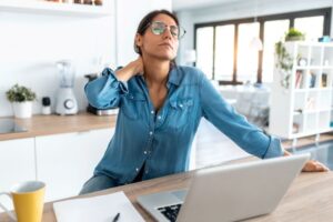 Woman suffering from neck pain as she works at her computer