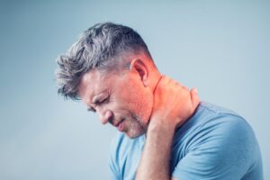 Man touching his neck, experiencing pain
